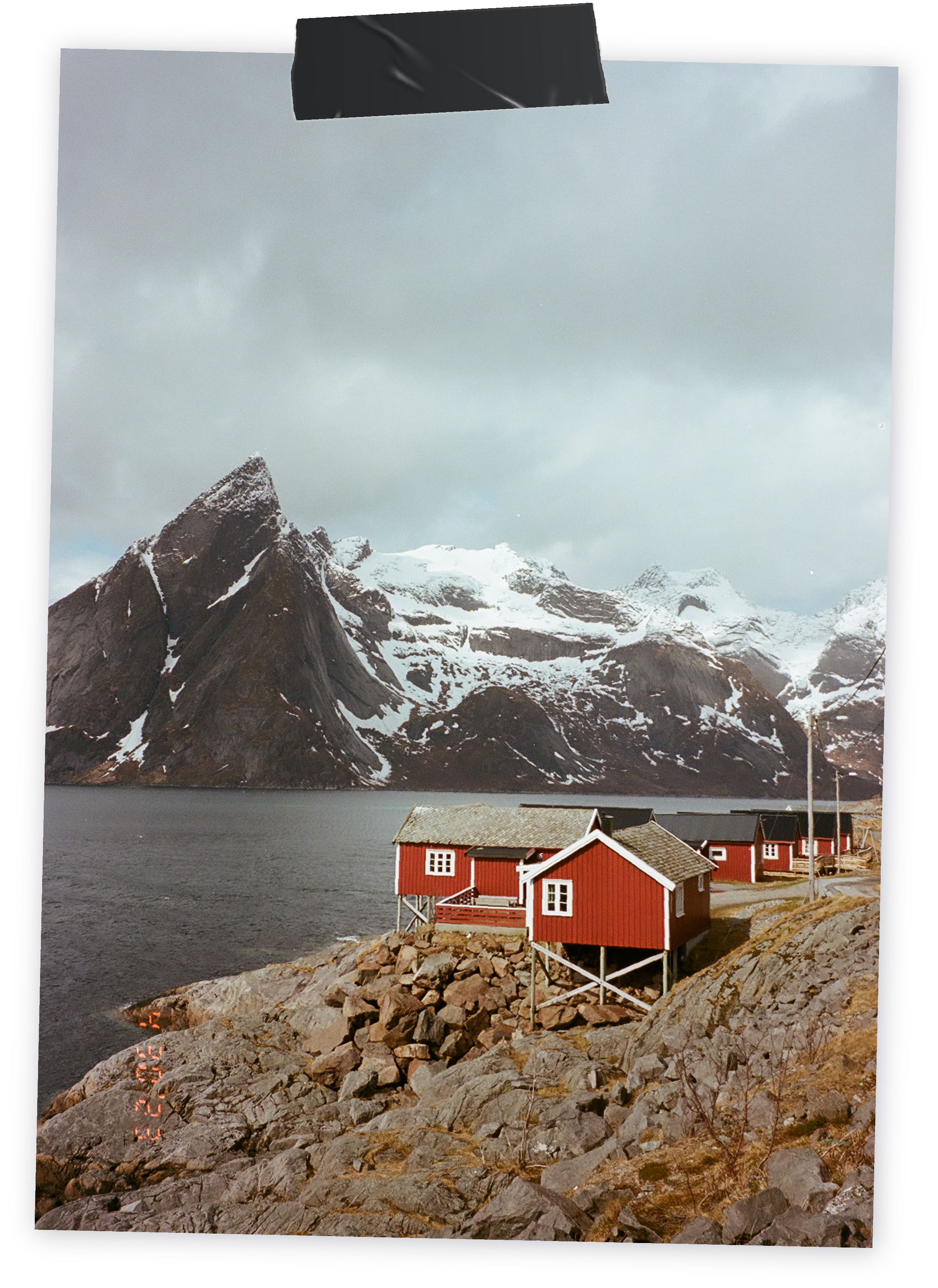 A red fisherman cabin with a large mountain in the background.